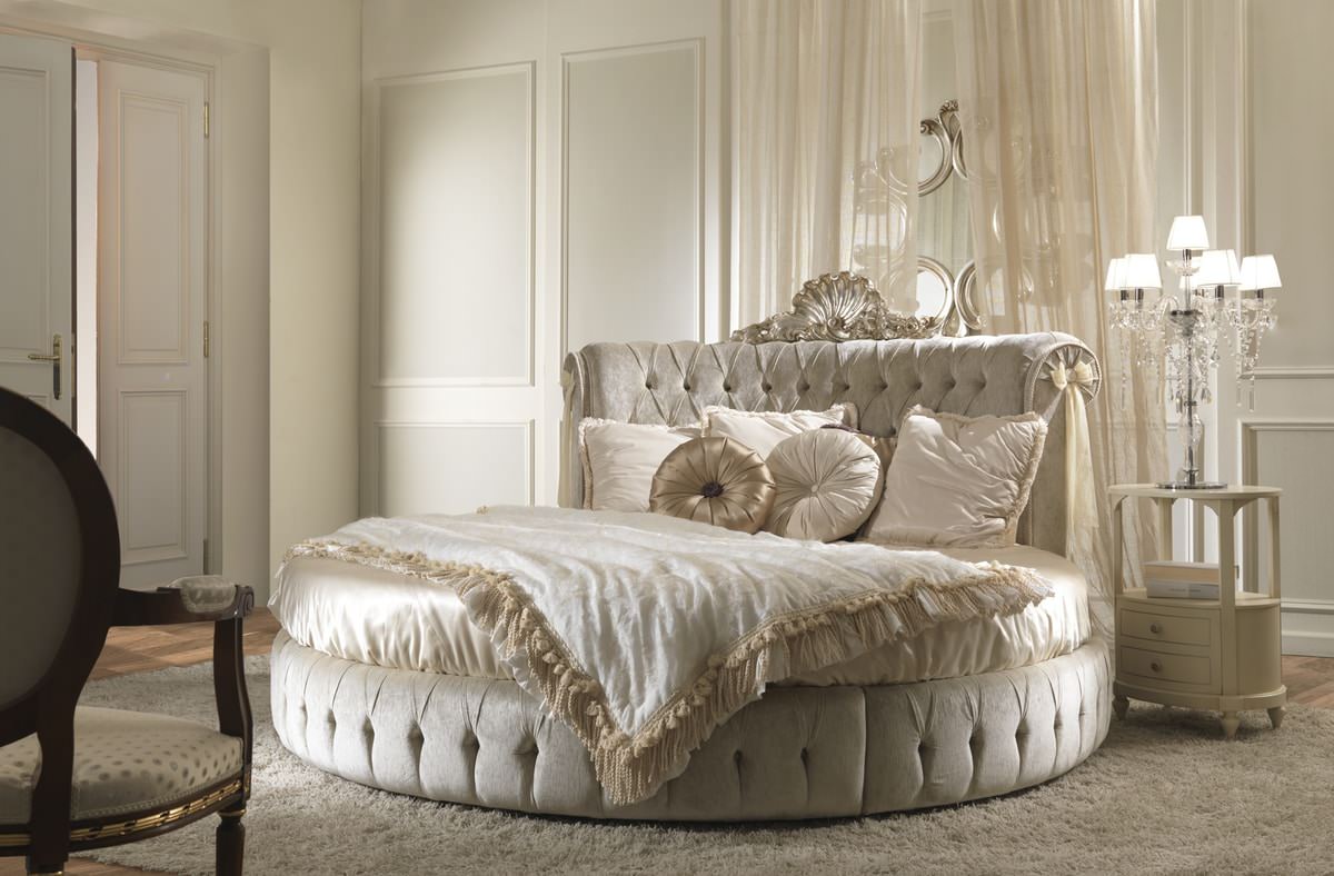 تخت خواب گرد کلاسیک و سلطنتی دکمه کاری شده و با چهارچوب حکاکی شده که جلوه ای لوکس به اتاق داده است